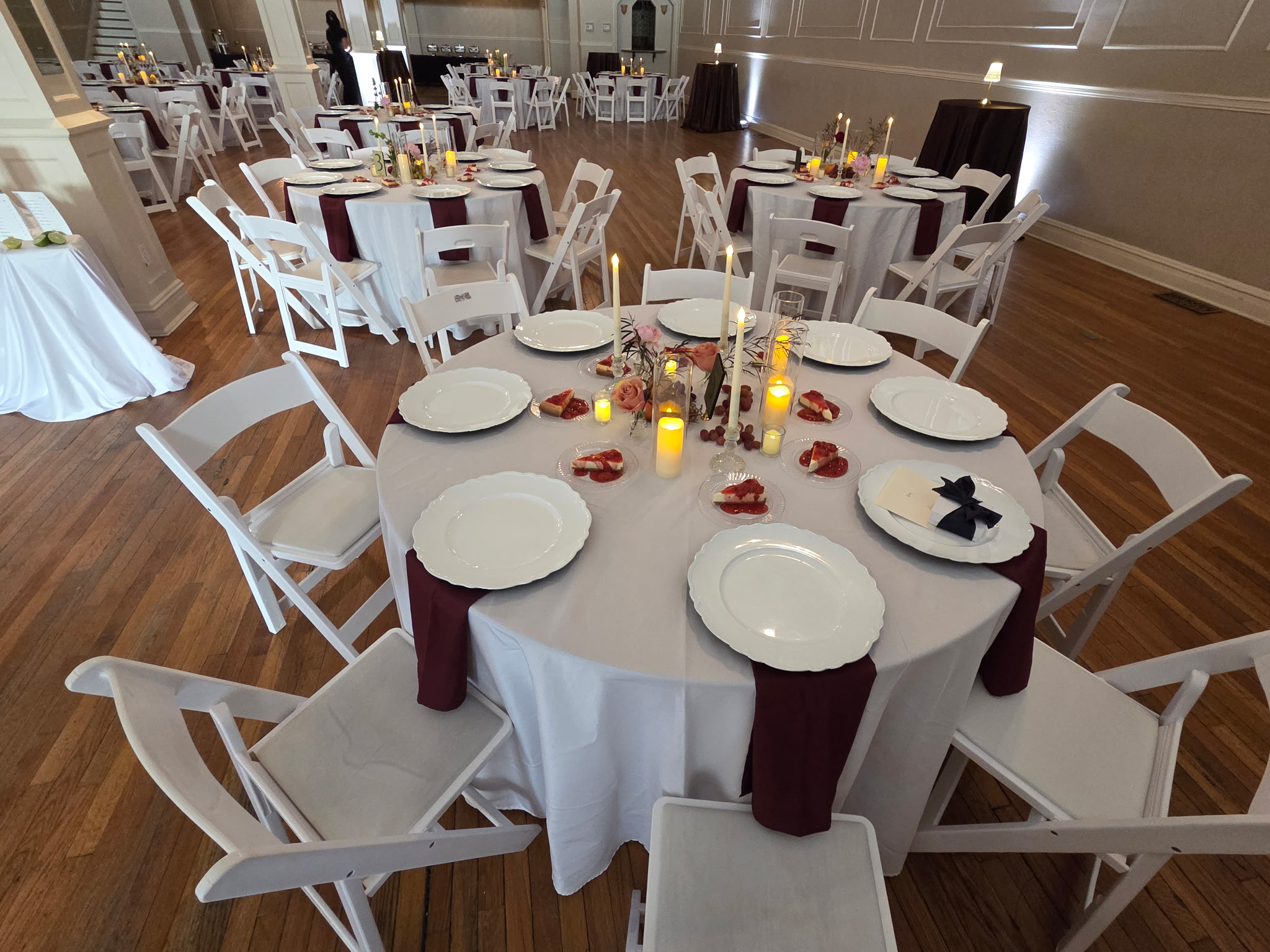 Close up image of a table set with chairs, plates, and candles